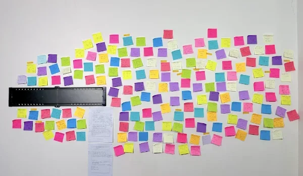 A photo of our living room wall. It's covered in about 150 brightly-coloured Post-it notes. You can't read what's on the notes.