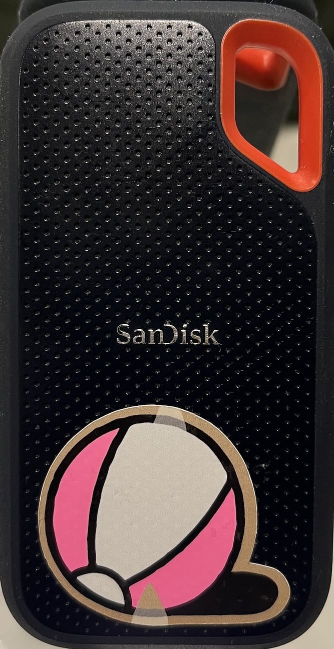 A photo of the SSD with a pink and white beachball sticker.